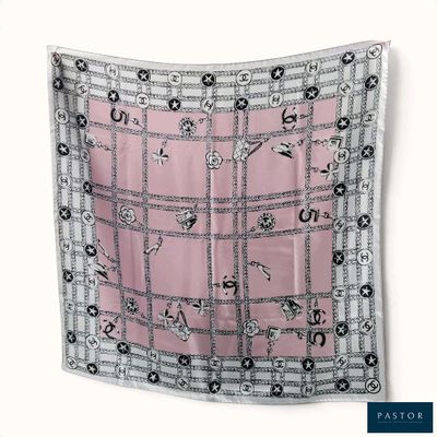 une photo d'une écharpe carrée rose et noire ornée de motifs noirs et blancs