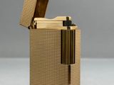 un gros plan d'un briquet doré posé sur une surface blanche