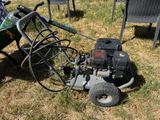 a lawn mower sitting in the grass next to a wheelbarrow