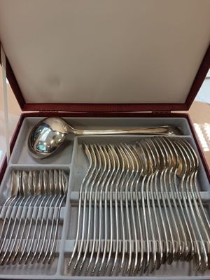 beaucoup de couverts dans une boîte posée sur la table