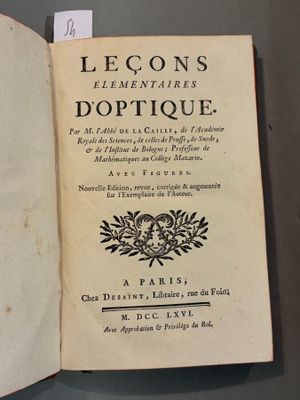 un livre ouvert sur une table, sur lequel est posée une étiquette