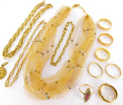 a lot of gold jewelry on a white surface