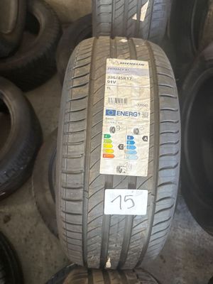 Des bandes de roulement et des pneus sont empilés sur une étagère dans un garage