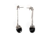 une paire de boucles d'oreilles ornées de pierres noires sur fond blanc