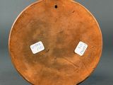a brown vase with stickers on it sitting on a table
