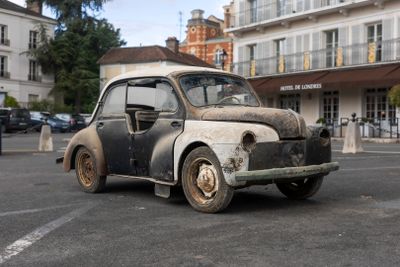 an old car that is sitting in the middle of a parking lot