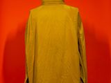 an image of a yellow jacket on a mannequin stand against a red wall