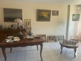 a room with a table, chairs, pictures and pictures on the wall