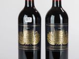 deux bouteilles de vin rouge posées l'une à côté de l'autre sur une surface blanche