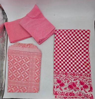 une serviette rose, une serviette rose et une serviette rose posées sur un plateau