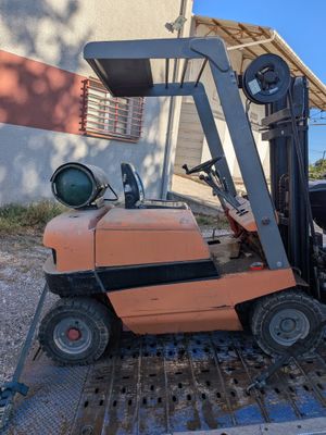 a forklift that is sitting on the back of a truck