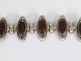 a group of five silver and garnet stone bracelets