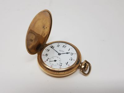 an old pocket watch sitting on top of a white table