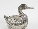 a silver duck shaped box sitting on top of a white surface