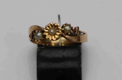 une image montrant un gros plan d'une bague en or posée sur une surface noire