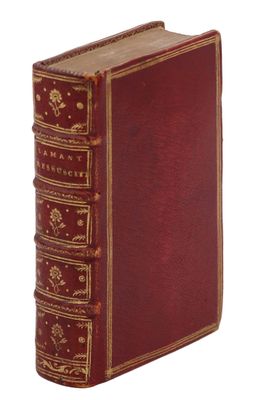 un vieux livre avec une couverture rouge et des bordures dorées sur fond blanc
