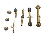 plusieurs objets en laiton et en verre bleu posés sur une surface blanche