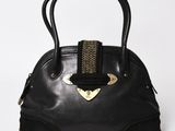 a black handbag with a gold metal handle on a white background