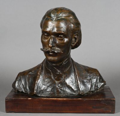 a bronze bust of a man with a mustache on a wooden base
