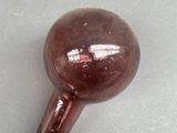a brown glass ball sitting on a white surface