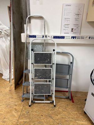 une échelle posée à côté d'une pile de chaises