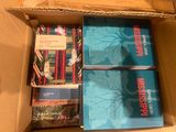 books in a cardboard box on a table with other books