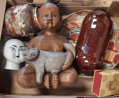 une boîte contenant une statuette représentant un enfant et un chat
