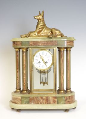 une horloge en or surmontée d'un chien