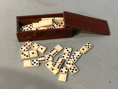 un lot de dominos dans une boîte en bois sur la table