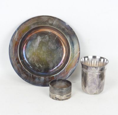 une assiette en argent et une tasse en argent placées l'une à côté de l'autre