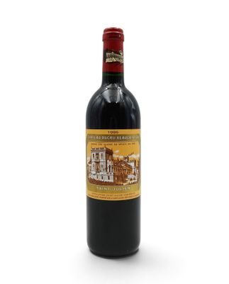a bottle of red wine sitting on top of a white table