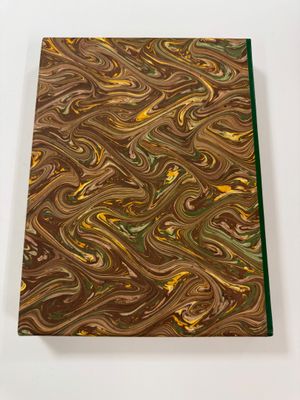 a close up of a brown and green marbled book on a white surface