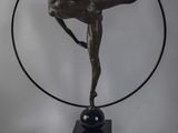 statue représentant une danseuse dans un cerceau, posée sur un socle en marbre