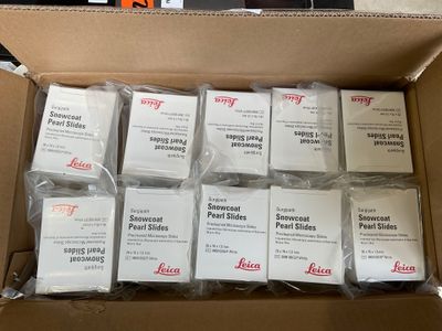 une boîte en carton remplie d'une pile de lames de verre