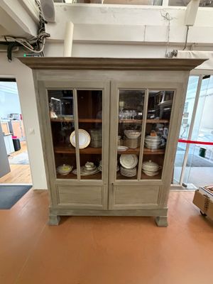 a cabinet with a glass door in the middle of a room