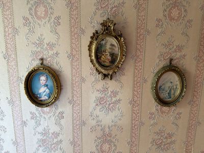 three framed pictures on the wall above a toilet