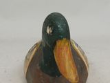 a small duck that is sitting on a white surface