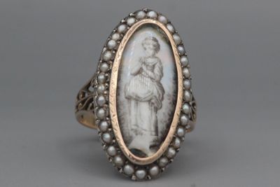 une bague ancienne en argent représentant une femme tenant un enfant dans ses bras