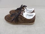 brown and white sneakers with black laces on them on a white surface