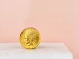 a gold coin sitting on top of a white pedestal