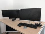 a computer desk with two monitors and a keyboard