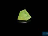 un gros plan d'un cristal vert sur une surface noire