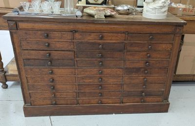 une commode en bois surmontée de nombreux tiroirs