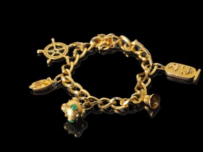 bracelet à breloques plaqué or avec des breloques sur fond noir