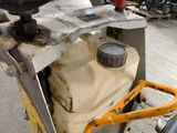 a machine that is sitting on the ground with a yellow handle