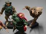 five figurines of people dressed in green and red
