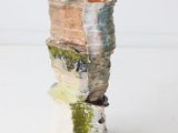 a small vase that is made out of paper and wood