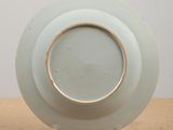 a white plate with a brown rim sitting on a table