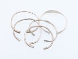 three silver rings on a white surface with a white background