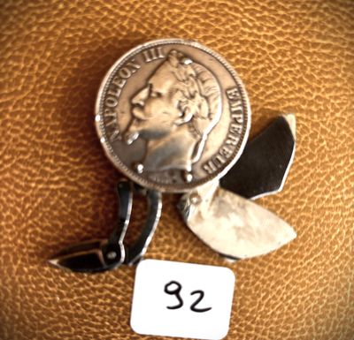 a small silver coin with a small blade attached to it